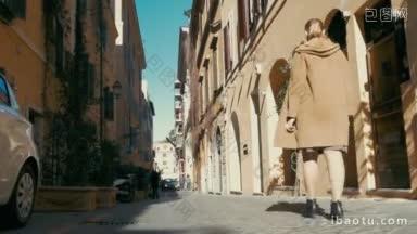 斯坦尼康和低角度拍摄的一个女人在外套走在古老的狭窄的街道在欧洲她